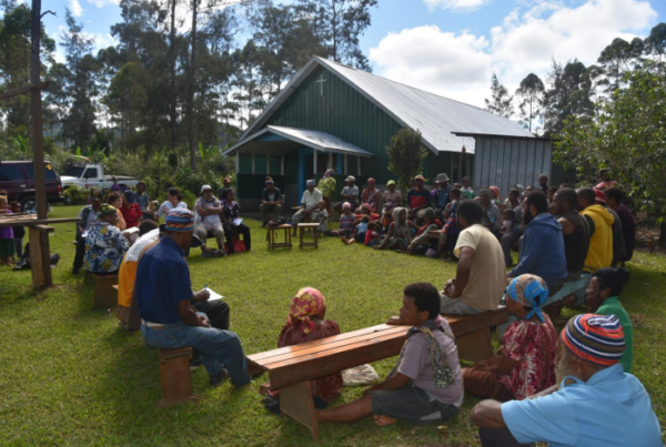 Group of people sitting outside in a circle
